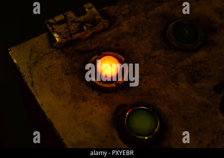 The shining red button of the electric control panel of the industrial machine Stock Photo