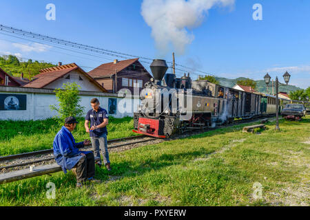 Romania, Viseu de Sus. Traindrivers taking a cigarette break before starting their historic steam train for a tourist ride Stock Photo