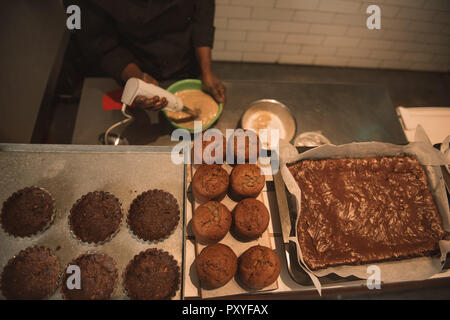 Baker mixing batter for muffins in a commercial kitchen Stock Photo