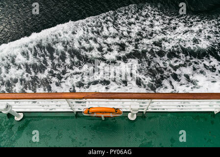 Lifebuoy at the side. Top view of the ferry deck, rails, lifebuoy and foaming sea water Stock Photo
