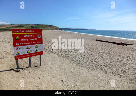 A warning sign warning of strong currents and advising people not to bathe, on Loe Bar near to Helston, Cornwall, England, UK Stock Photo