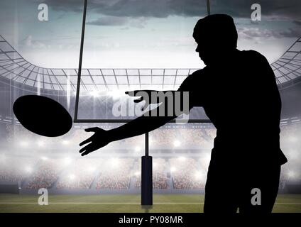 Digital composition of silhouette of player catching a rugby ball in stadium Stock Photo