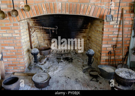 Antique rustic kitchen fireplace with old cooking utensils. Interior of home at Chestnut Square Historic Village, McKinney Texas. Stock Photo