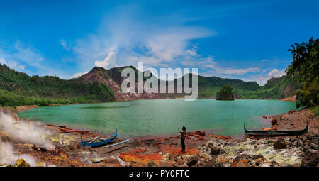 Woman taking picture in front of Taal Volcano crater lake and mountains, Tagaytay, Batangas, Philippines Stock Photo