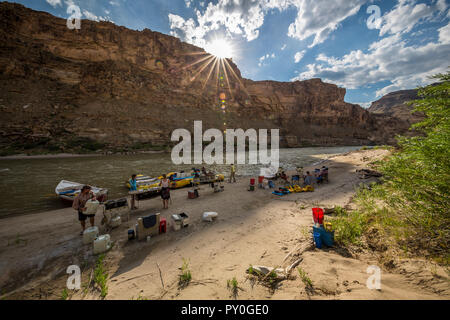 Sun shining over group of friends camping in Desolation Canyon on riverbank of Green River, Utah, USA Stock Photo