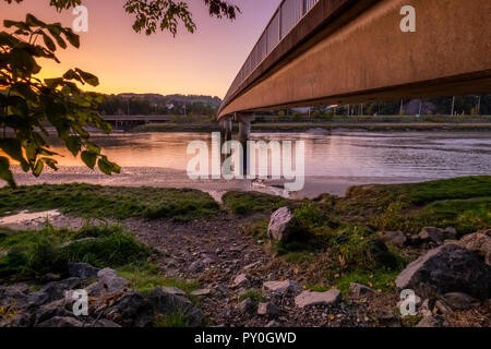 Sunset on an oddly hot October day catches the bridge over the Leven Estuary at Greenodd in Cumbria. Stock Photo