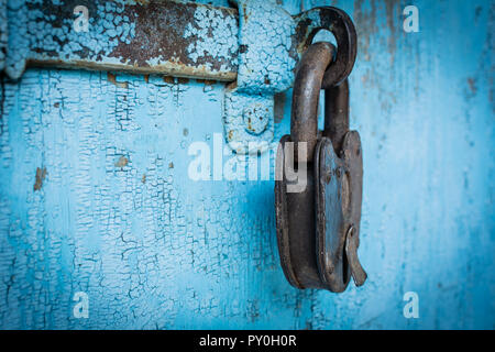 Rusty grunge padlock on old blue wood wall background Stock Photo