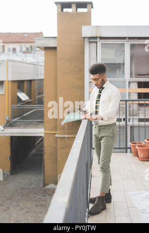 young black man outdoor using smart phone - business, remote working, technology concept Stock Photo