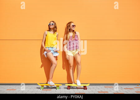 teenage girls with short skateboards outdoors Stock Photo