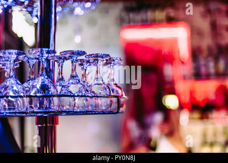 rack with empty clean wine glasses in night bar Stock Photo