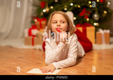 girl writing christmas wish list at home Stock Photo