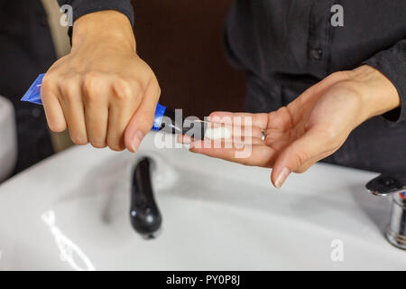 the hairdresser applies shampoo to the client's hair. Stock Photo