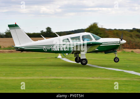 Piper PA28 Cherokee Arrow G-AWAZ in a spot landing competition at Elmsett Airfield, Suffolk, UK. About to land on the target line. Grass airfield Stock Photo