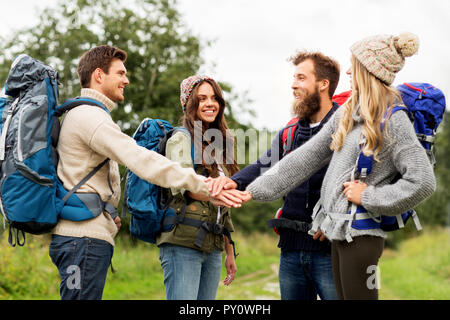 friends with backpacks hiking and stacking hands Stock Photo