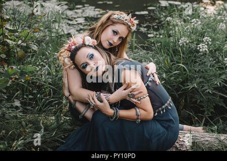 Two boho women sitting by a lake, Russia Stock Photo
