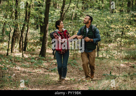 couple of travelers with backpacks hiking in forest Stock Photo