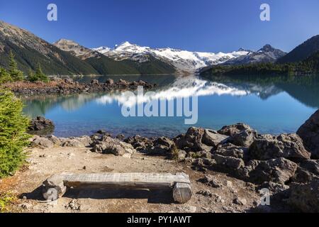 Wooden Log Bench Scenic Mountain Landscape Calm Water Reflection Garibaldi Lake Park Coast Mountains Skyline Pacific Northwest British Columbia Canada Stock Photo