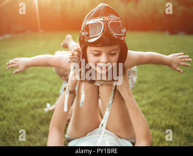 Little pilot - girl having fun with a young, relaxed mom Stock Photo