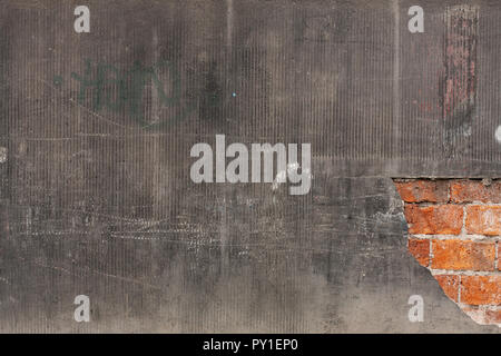 Plastered wall background with  a brick wall showing through a damaged part of the wall Stock Photo