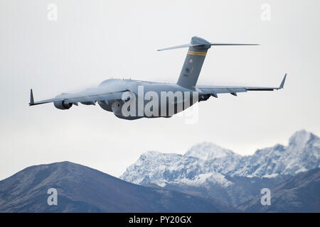 An Air Force C-17 Globemaster III, assigned to the 535th Airlift Squadron, out of Joint Base Pearl Harbor-Hickam, Hawaii, takes off from Joint Base Elmendorf-Richardson, Alaska, during Arctic Anvil 19-01, Oct. 9, 2018. Arctic Anvil is a joint, multi-national, force-on-force training exercise designed to provide a realistic training event to validate participant’s ability to fight and win as a combined arms team. The 535th AS performed personnel and heavy equipment airdrops in a simulated contested environment and potentially semi-prepared runway ops. (U.S. Air Force photo by Alejandro Peña) Stock Photo