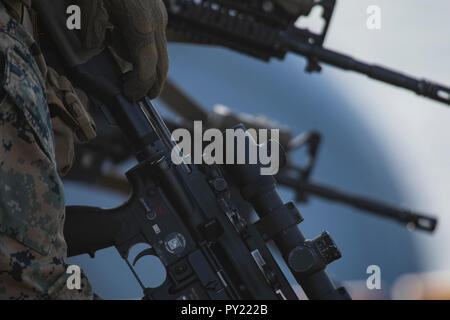 A Marine with Battalion Landing Team, 1st Battalion, 2nd Marine Regiment, 22nd Marine Expeditionary Unit, loads his M27 Infantry Automatic Rifle before starting live-fire deck shoot during the Carrier Strike Group (CSG) 4 composite training unit exercise (COMPTUEX) aboard the Wasp-class amphibious assault ship USS Kearsarge (LHD 3), Oct. 22, 2018. COMPTUEX is the final pre-deployment exercise that certifies the combined Kearsarge Amphibious Ready Group (ARG) and 22nd Marine Expeditionary Unit’s (MEU) abilities to conduct military operations at sea and project power ashore through joint plannin Stock Photo