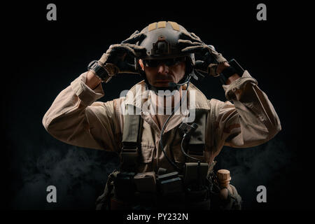 special forces soldier of the united states poses with a rifle on a black background Stock Photo