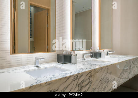 Interior of bathroom with washbasin faucet and black towel in hotel. Modern design of bathroom. Stock Photo