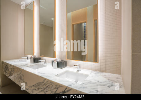 Interior of bathroom with washbasin faucet and black towel in hotel. Modern design of bathroom. Stock Photo