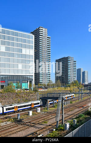 Transport for London tfl Overground suburban train on tracks between office & apartment development at Stratford & Olympic Park East London England UK Stock Photo