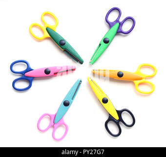 Six childrens pinking shears in a circle isolated on white Stock Photo
