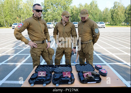 Men in military uniform standing in front of a table with fire-arms “Glock” placed on boxes. KORD (Ukrainian SWAT). September 5, Kiev, Ukraine Stock Photo