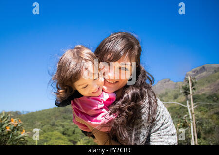 Portrait of a smiling mother hugging her daughter Stock Photo