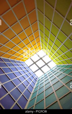 Abstract perspective of vertical lobby ceiling with skylight and strong geometry and symmetry and dramatic colors as background with space for copy Stock Photo