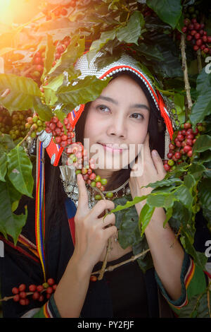 Portrait of a smiling woman standing next to coffee plants, Thailand Stock Photo