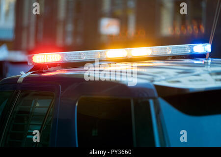 Police car traffic stop with three siren lights simultaneously blinking - red, yellow and blue .