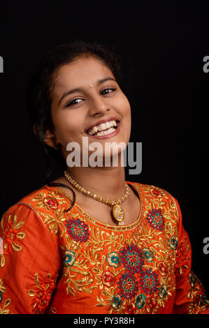 Portrait of a happy young Indian girl smiling on black background. Stock Photo