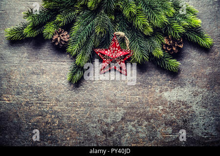 Christmas star spruce branches and cones on dark board. Stock Photo