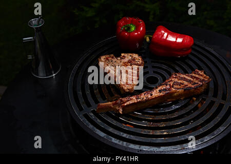 Tomahawk rib beef steak and T-bone on hot black grill. Stock Photo