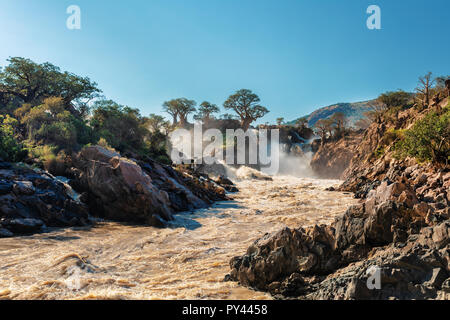 famous Epupa Falls on the Kunene River in Northern Namibia and Southern Angola border. Sunrise sunlight in water mist. This is africa. Beautiful lands Stock Photo