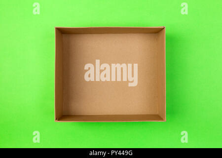 empty cardboard paper box on green background. delivery concept, top view. Stock Photo