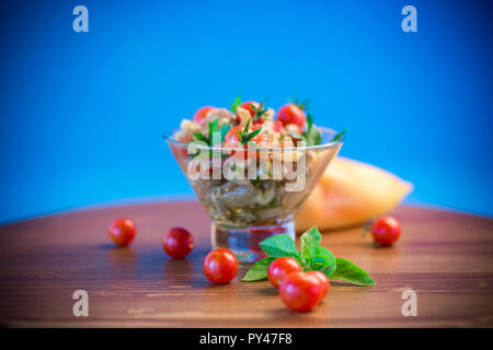 A warm salad of baked eggplant and peppers with cherry tomatoes in a glass bowl Stock Photo