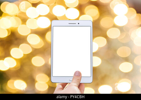 Christmas online sale. Tablet for buying gifts online. Tablet with an empty white screen on the background of Christmas decorations. Stock Photo