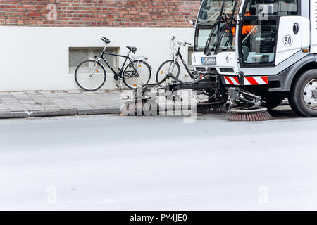 Germany, Muenster, October 5, 2018: A special truck or street cleaning vehicle rides along the road and cleans the street from dirt and dust. Stock Photo