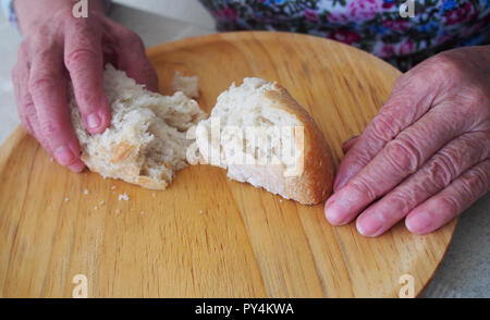 Woman hands holding keep bread. Pension, poverty, social problems and senility theme Stock Photo