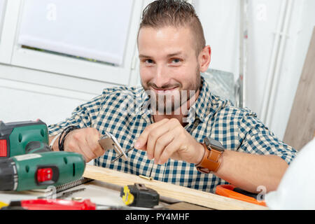 a young man measuring drill using caliper Stock Photo