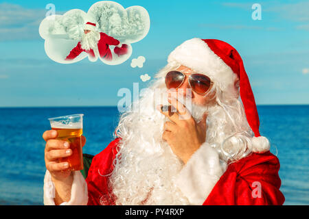 Santa Claus is sitting on the beach. He remembers the winter. Stock Photo