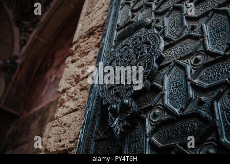 detail of cordoba mosque door carved in metal with patrons muslim. Stock Photo