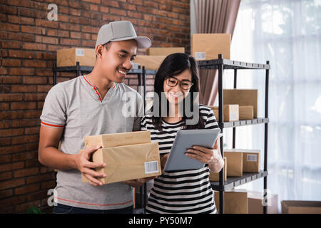 happy young asian business entrepreneur together smiling using tablet online Stock Photo