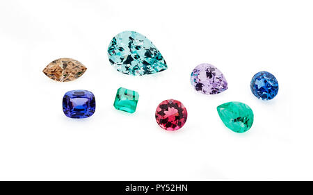 Group of coloured gemstones on a white background including emeralds, amethyst, sapphires, garnet and topaz Stock Photo