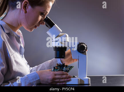 Young computer technician examining a printed circuit board. Microchip production factory. Stock Photo